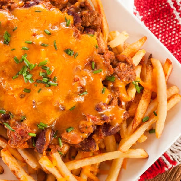 Golden french fries topped with melted cheddar cheese, chili, and fresh chives.